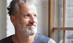 Aging man looking off, thinking about his financial wellness